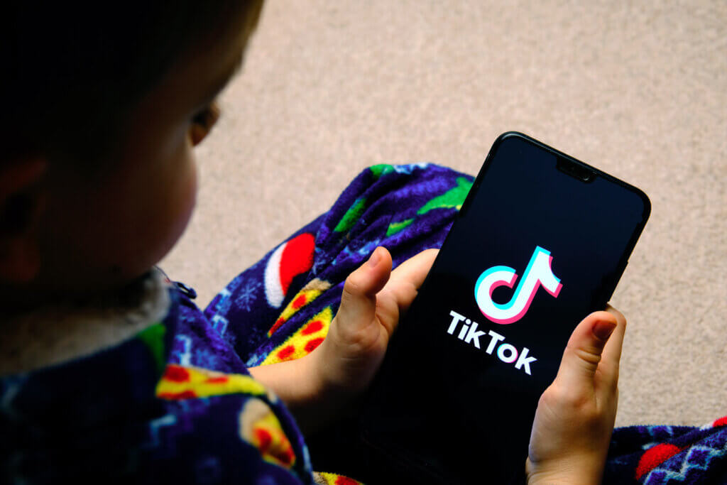 un niño sostiene un dispositivo móvil mientras usa tiktok