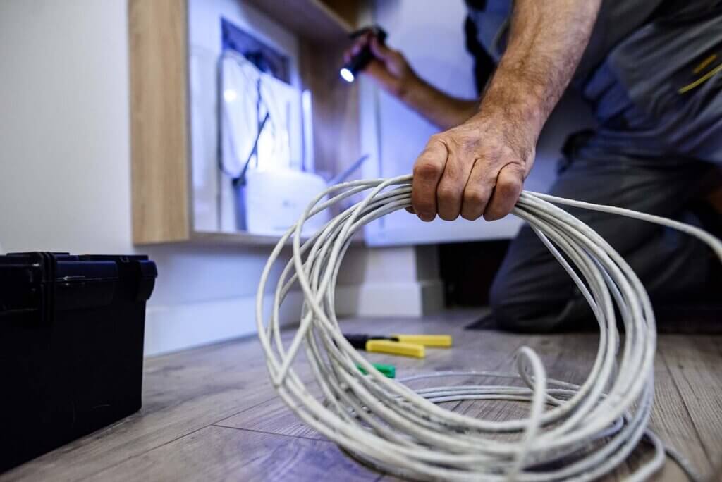 technician installing LAN cables into a home