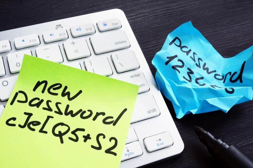 crumbled papers near a keyboard with new and old passwords