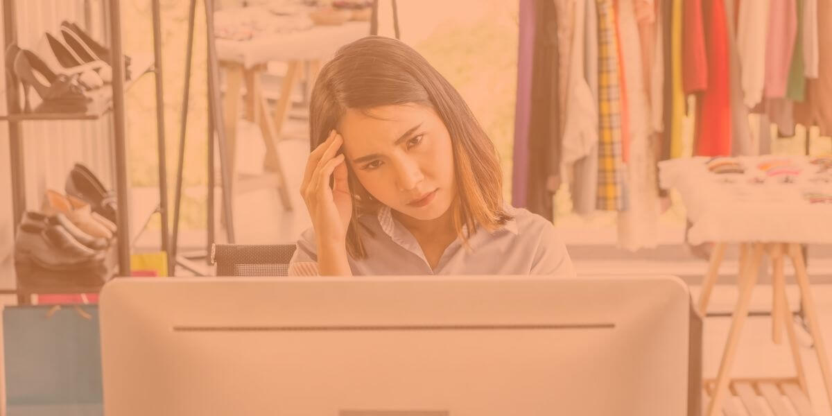 woman looking frustrated behind computer as she thinks of her slow internet speeds