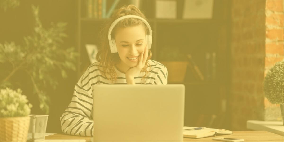 Una mujer que trabaja a distancia sonríe mientras mira su ordenador portátil con conexión a Internet de alta velocidad.