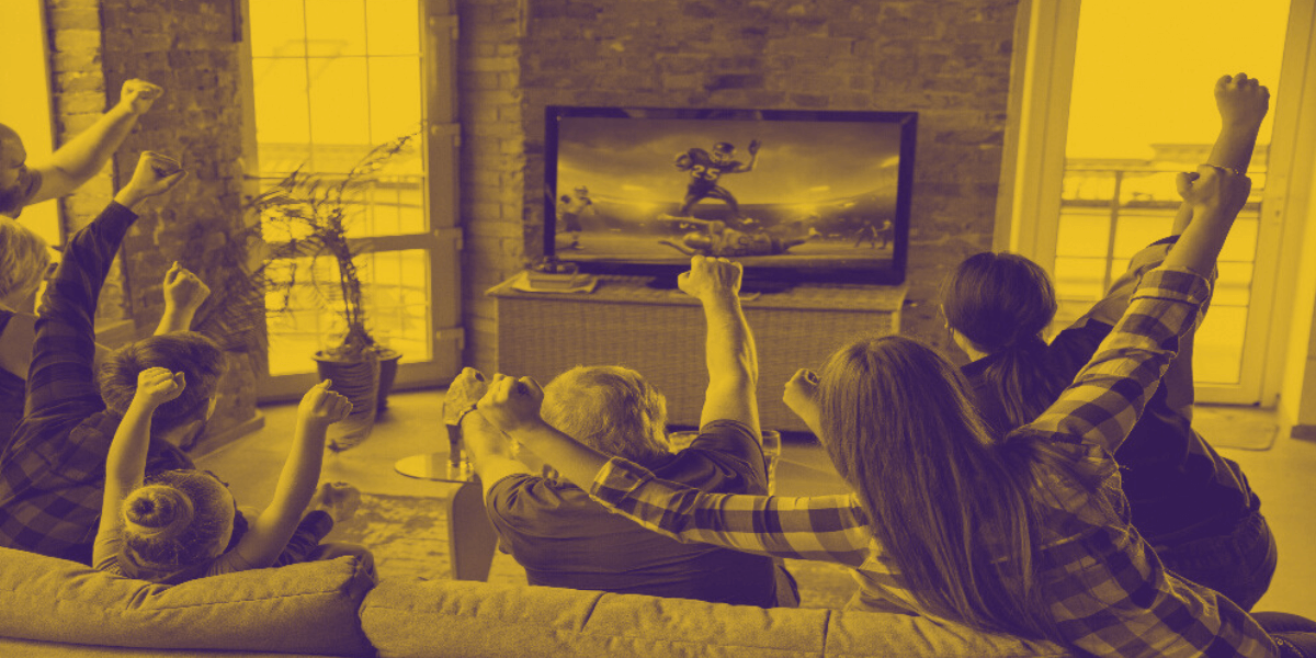 Familia disfrutando un partido de fútbol americano en la tele