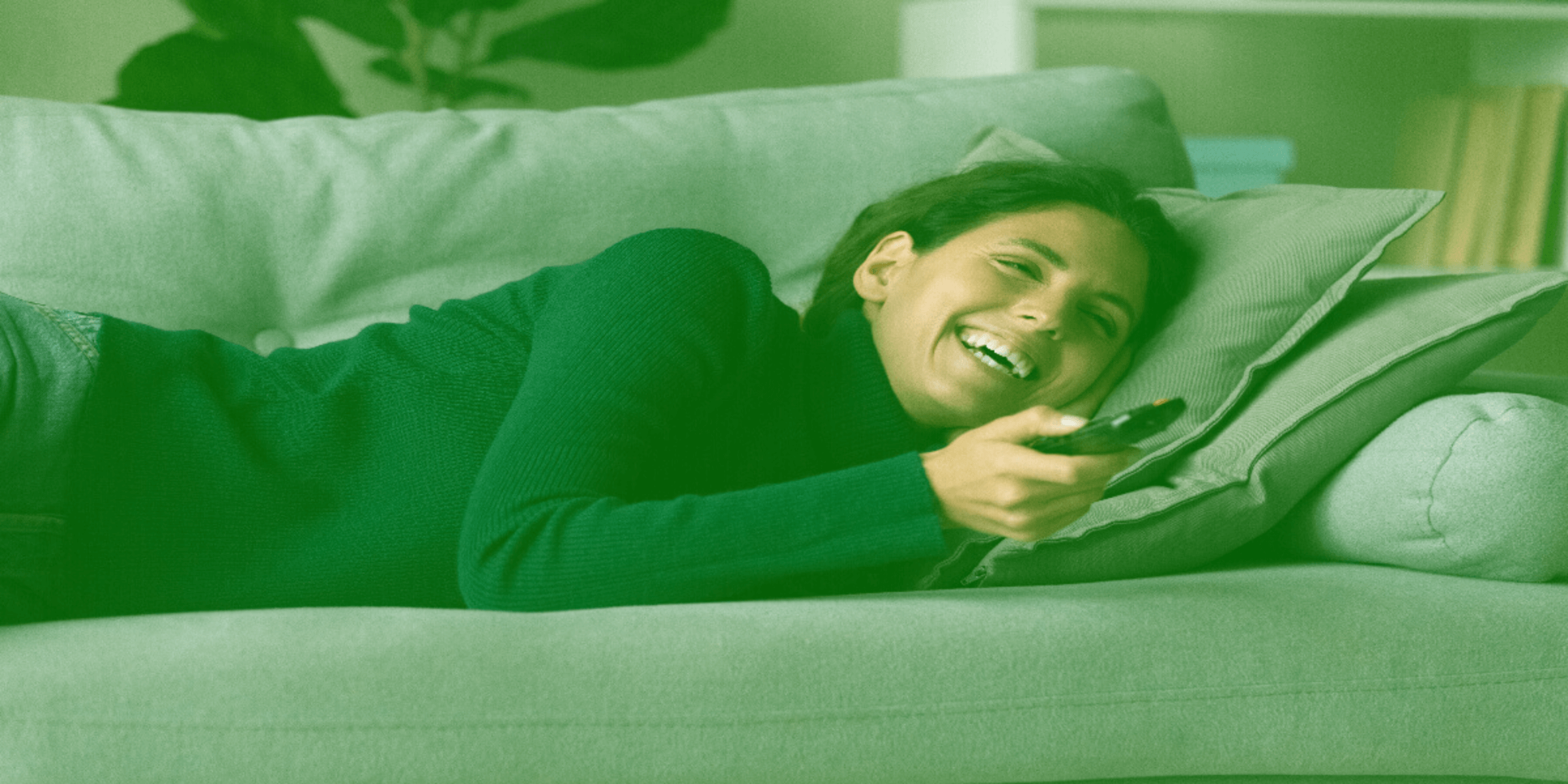 A woman watching TV in the sofa