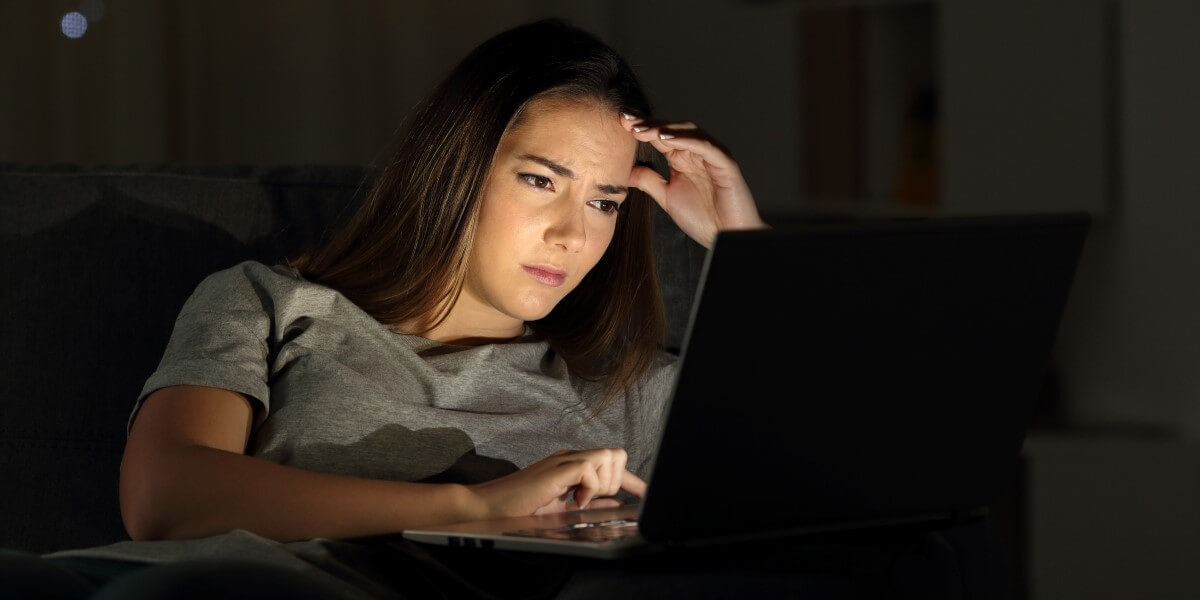 Woman concentrates while reading digital news to detect deepfakes