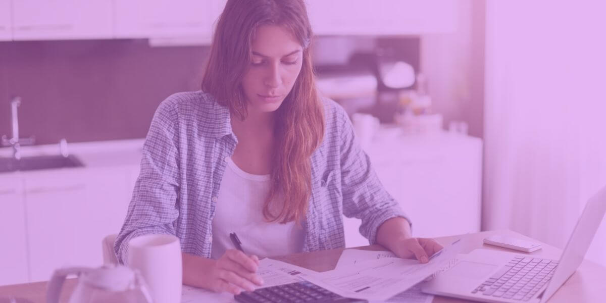 Woman looks worried sitting at laptop calculating extra internet fees