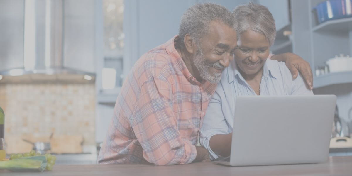 a senior couple smiles as they use their home internet connection