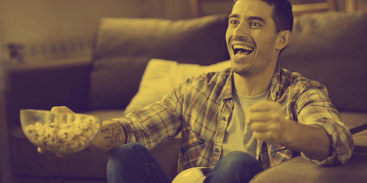 Man smiling while watching TV