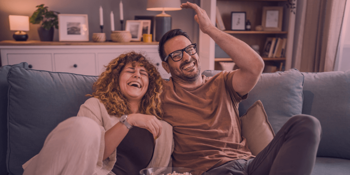 Couple laughing while watching TV