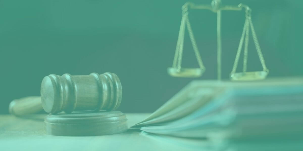 gavel and scales on desk with green filter