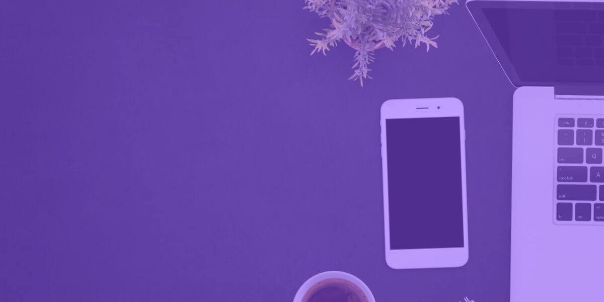 cell phone and laptop lying on purple desk