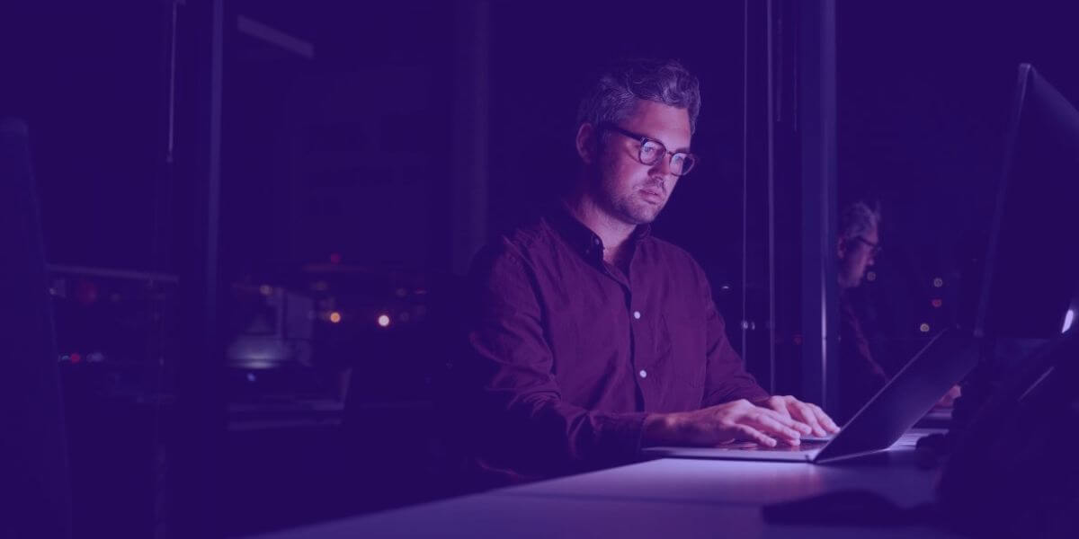 Man sits at desk looking at computer screen