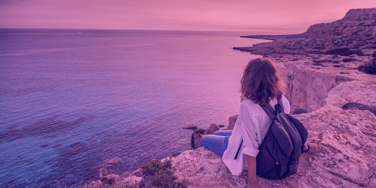 Traveler sit in a cliff watching the sea