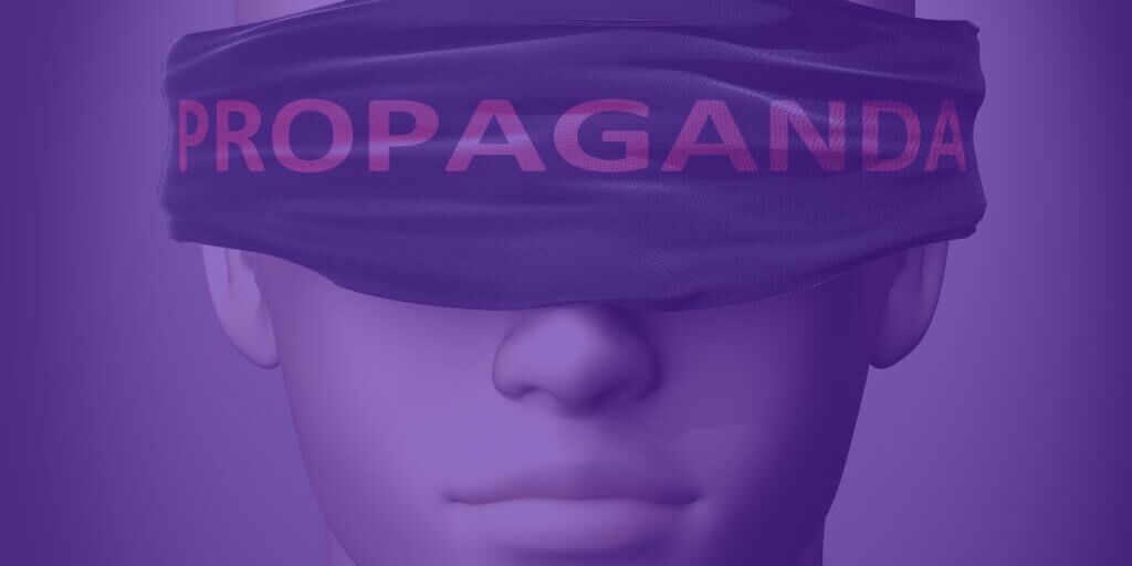 person blindfolded with a cloth that says "Propaganda"