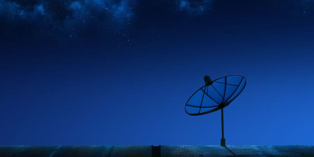 Satellite dish on roof at night in rural area