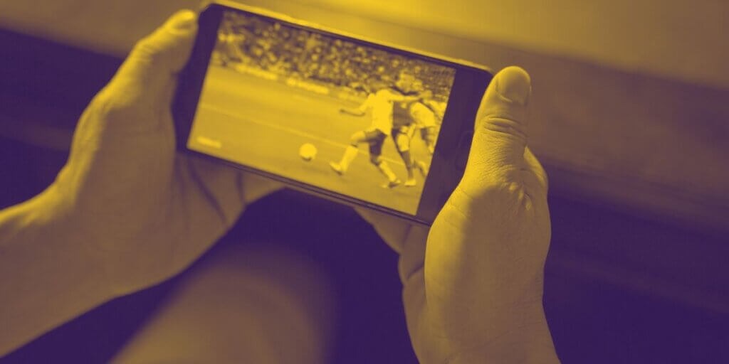 Mobile screen with soccer game held in man's hands