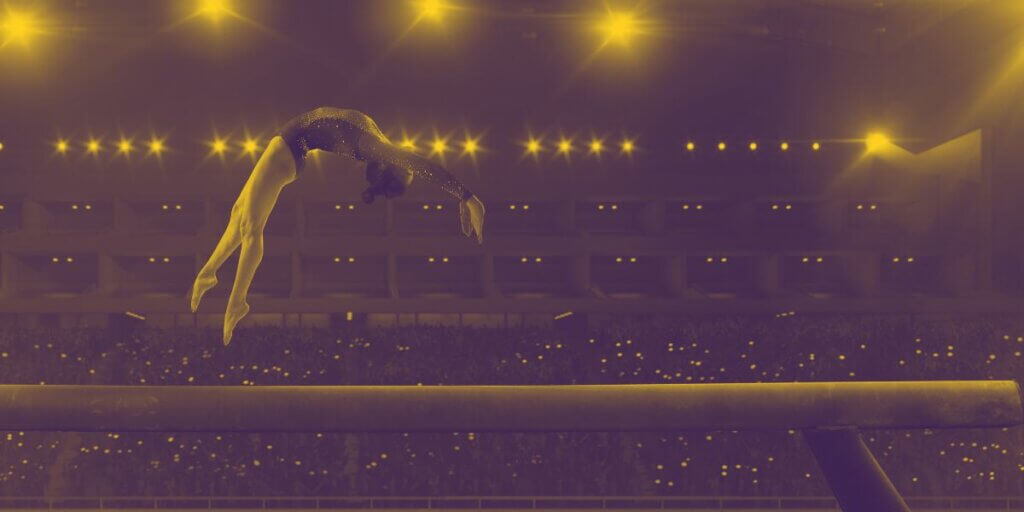 gymnast on beam in large stadium