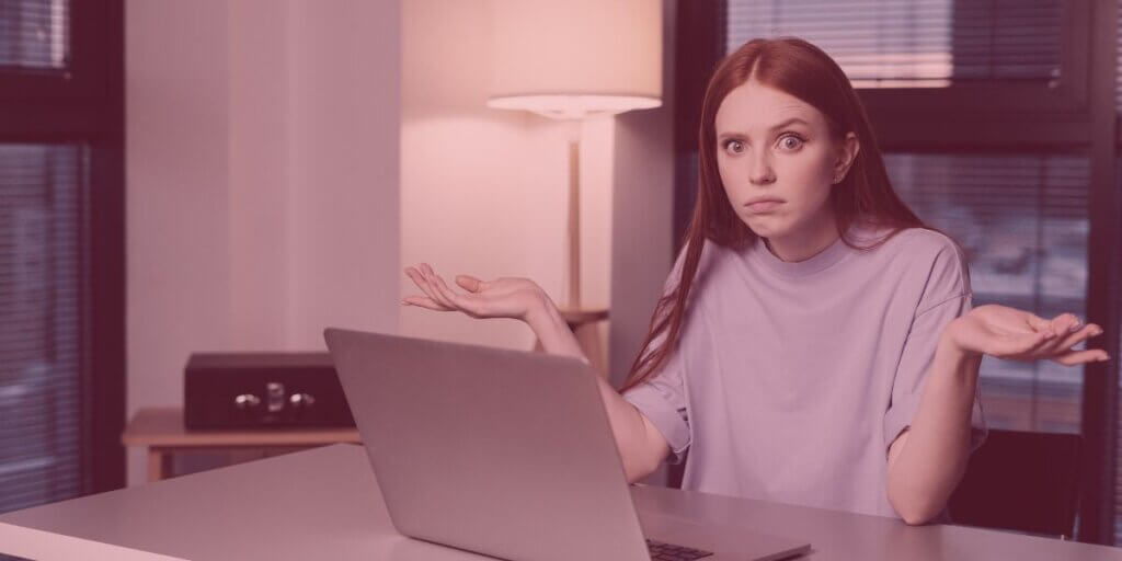 Woman looks frustrated while using laptop at home