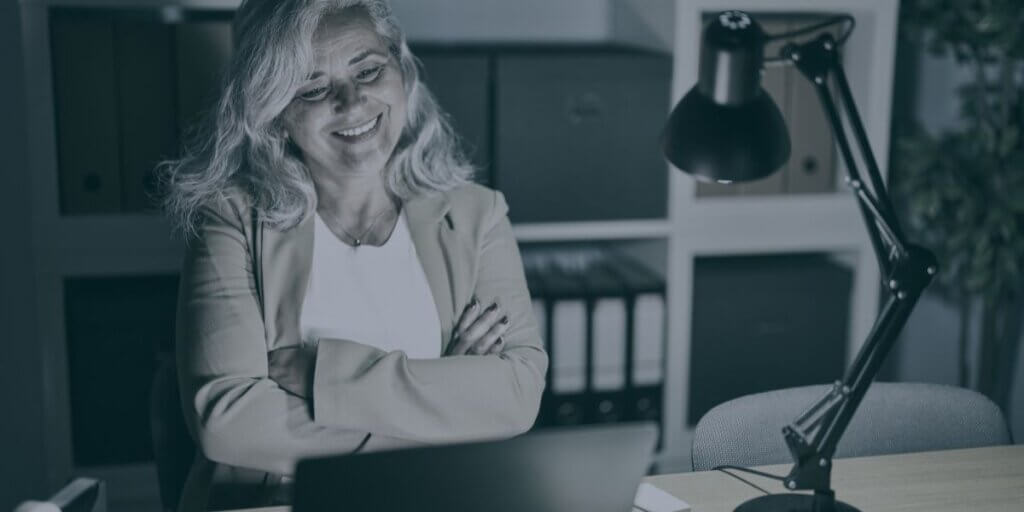 woman smiles looking at her laptop with unlimited data