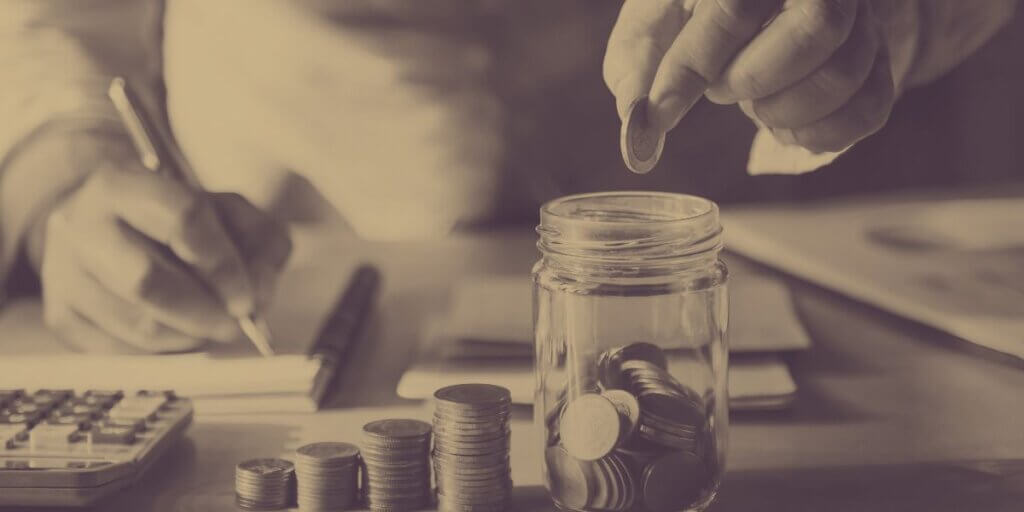 Hands counting money for budget with change jar