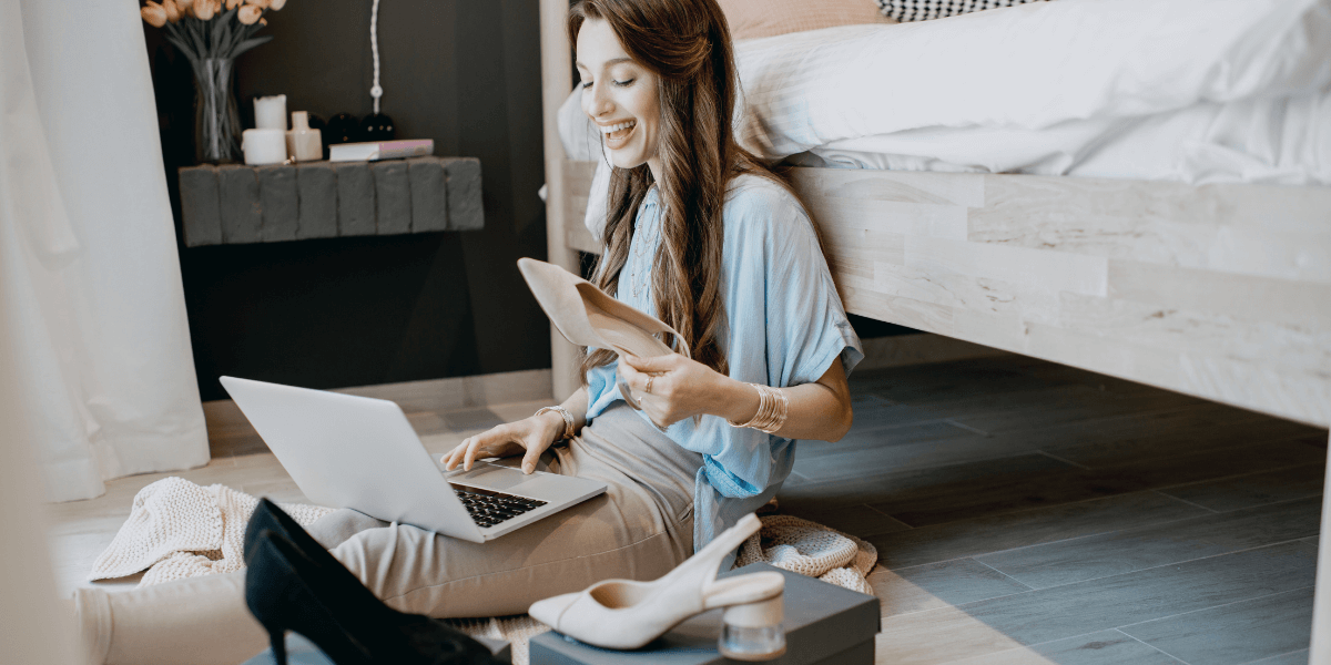 Young woman surrounded by shoes while shopping online