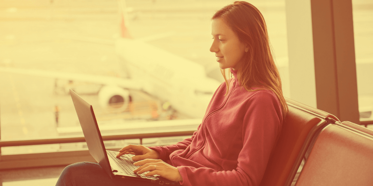 Young woman on her laptop in an airport