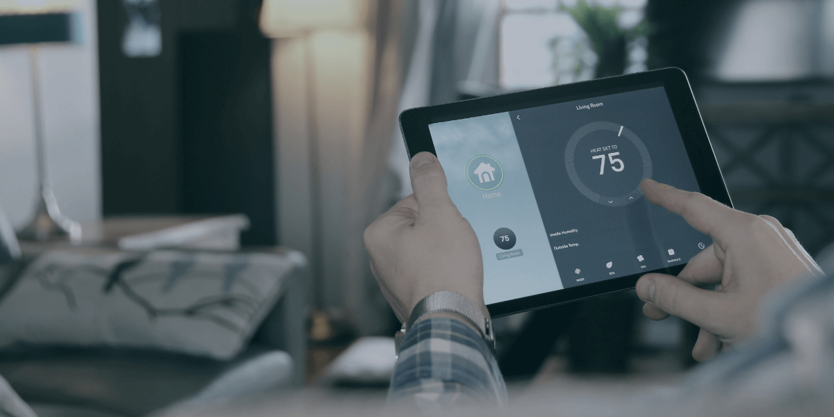 Person holding a tablet with their smart thermometer on the screen