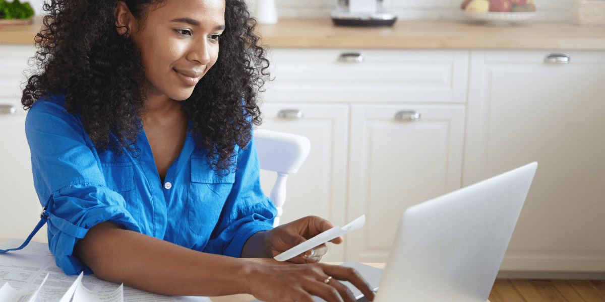 woman working on her computer with papers around her