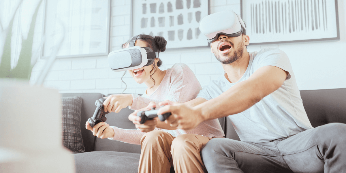 Man and woman sitting on couch both wearing VR headsets