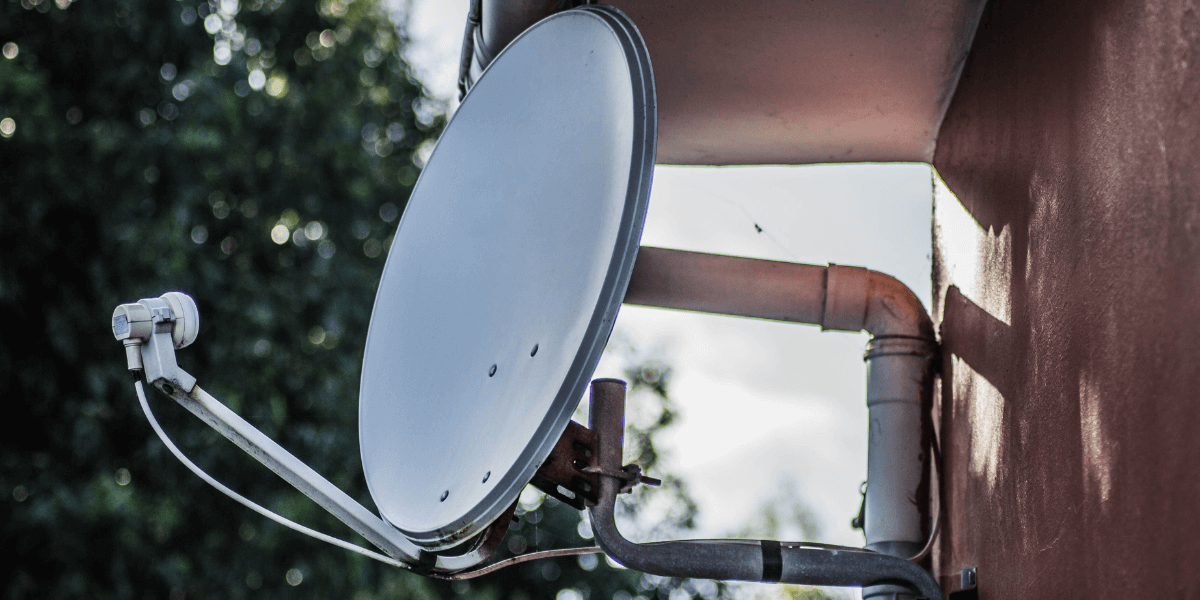 A fixed wireless internet satellite attached to the side of a house