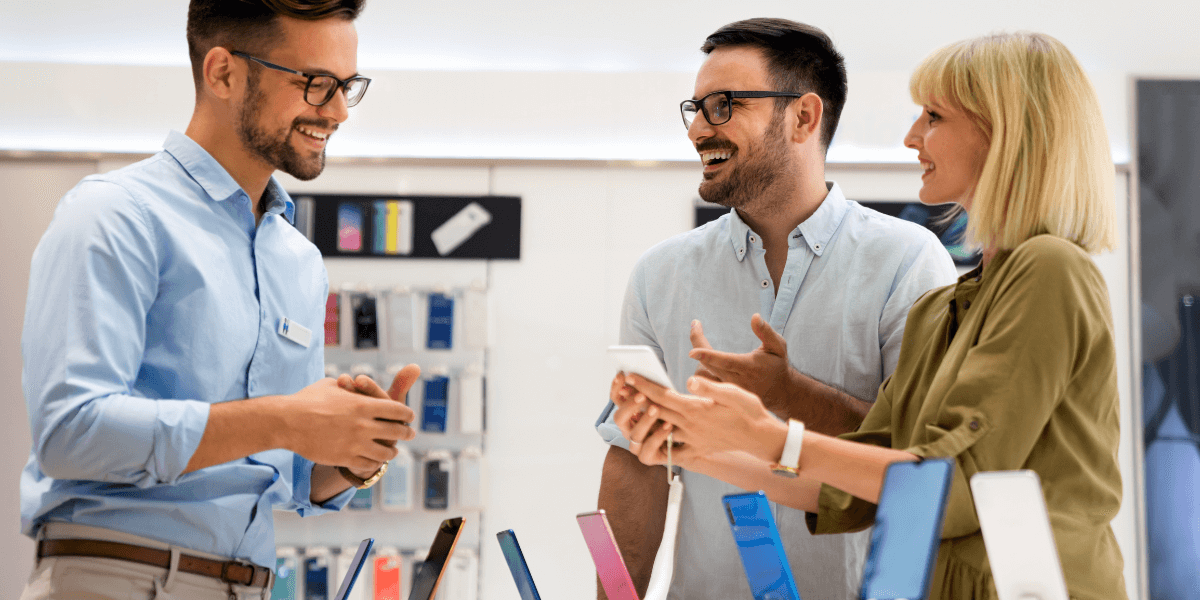 Sales person talking to people looking to buy a cell phone