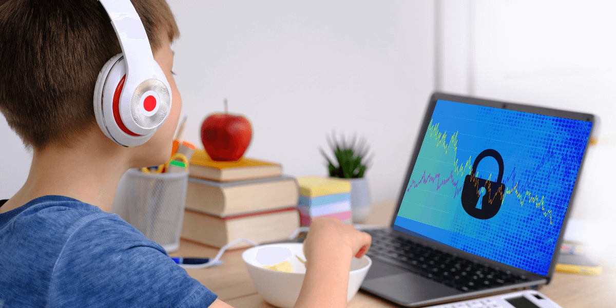 young boy wearing headphones working on a laptop