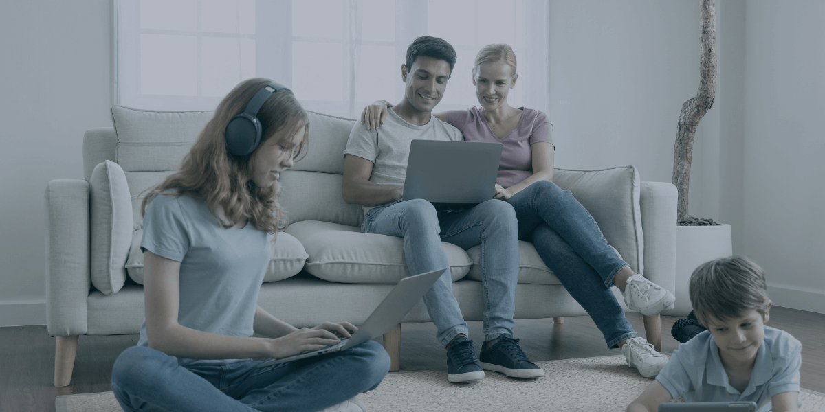 a family gathered in their living room, all using different devices