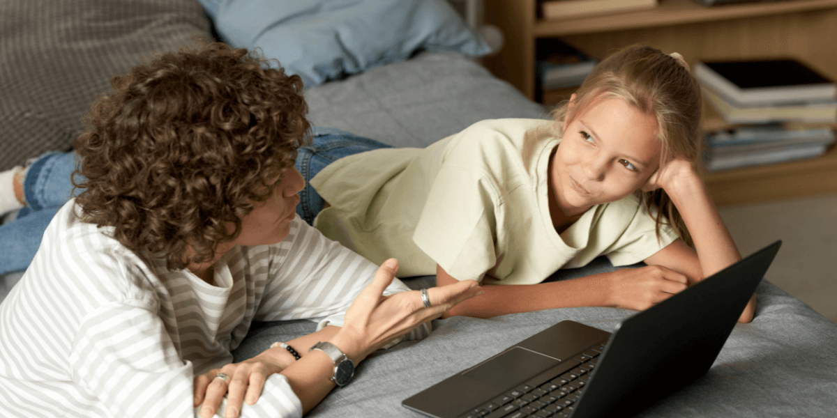 Mom and daughter on the bed with a laptop talking