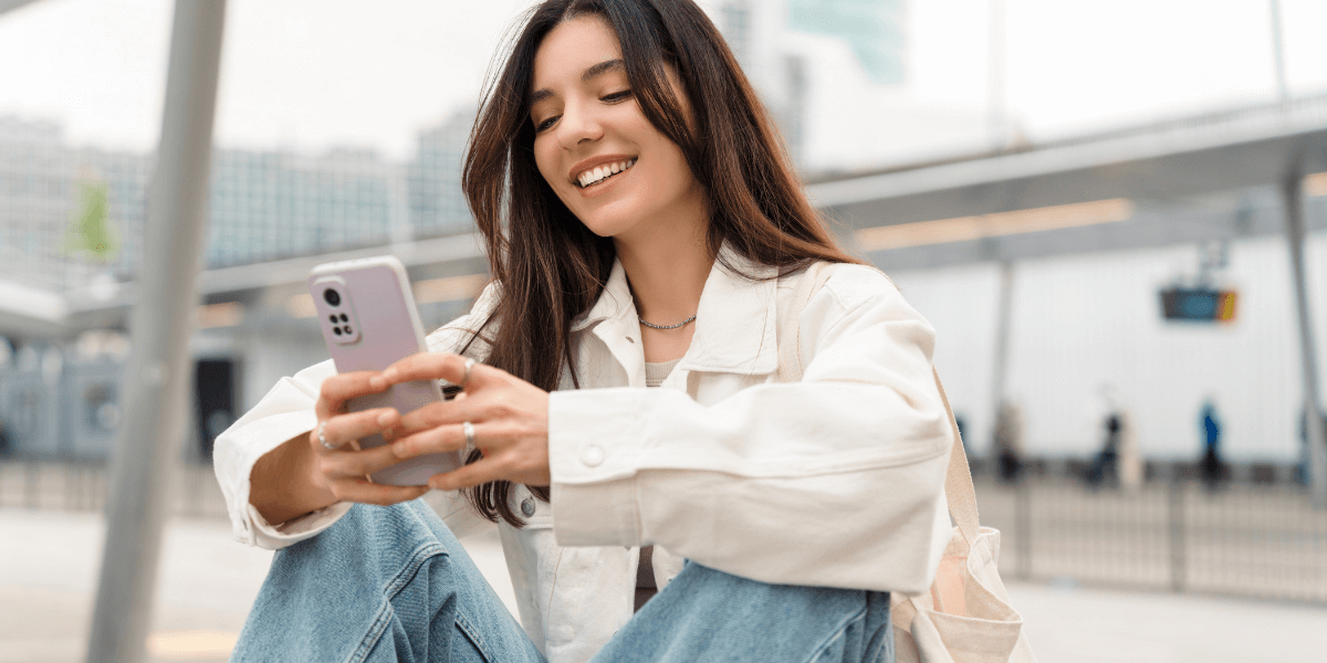 teen girl smiling at her cell phone