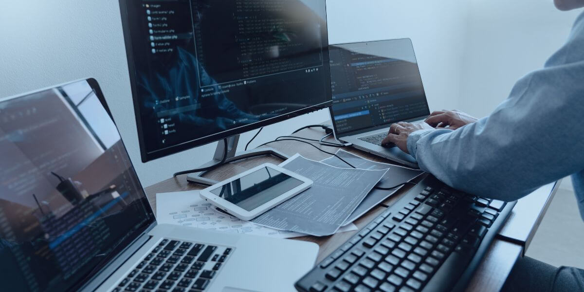 person working at desck with multiple monitors