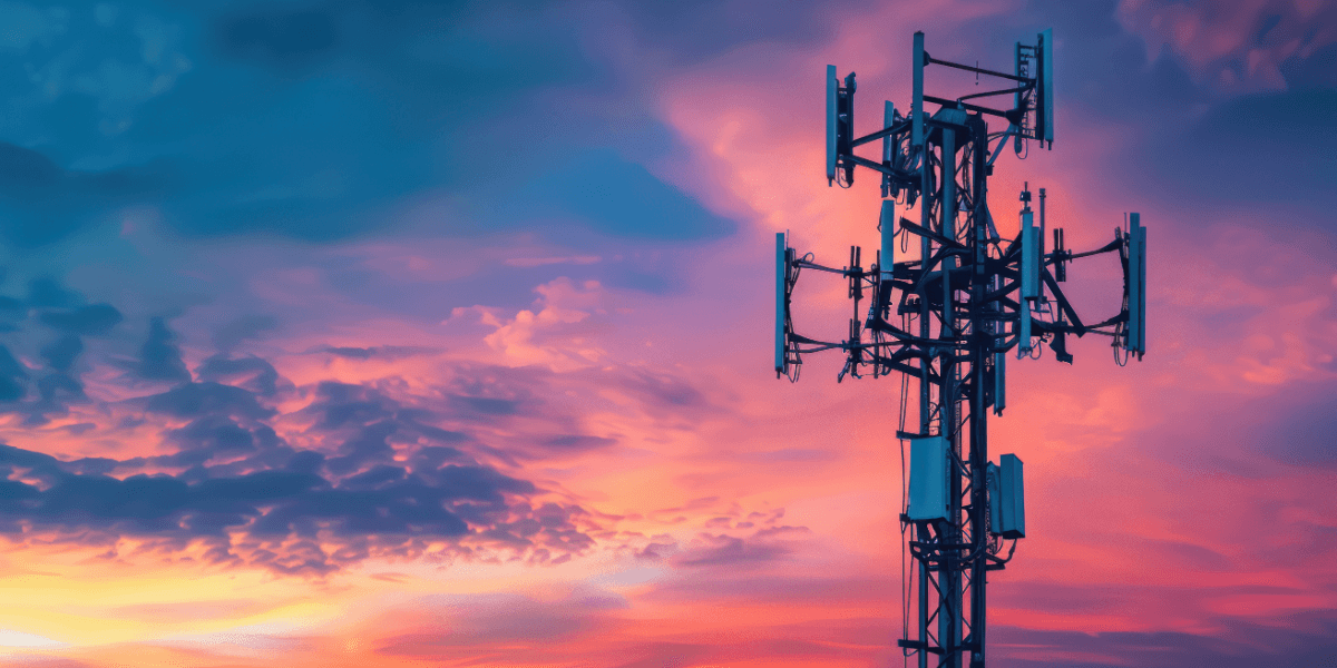 a cell tower with the backdrop of a sunset