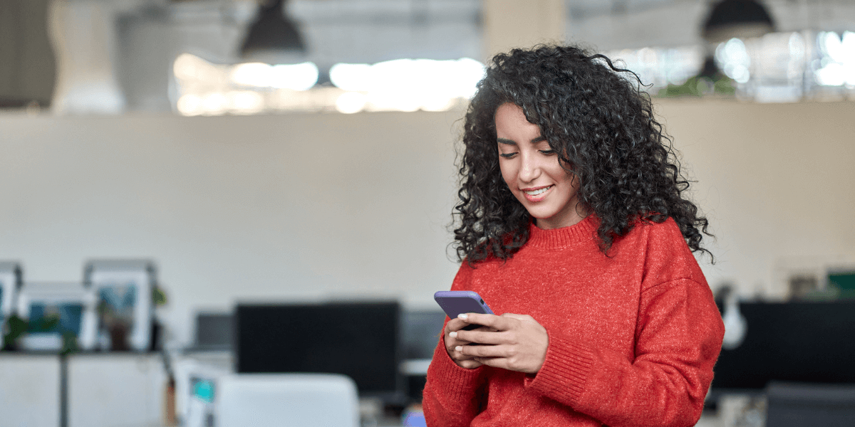 Girl smiling while typing on her phone