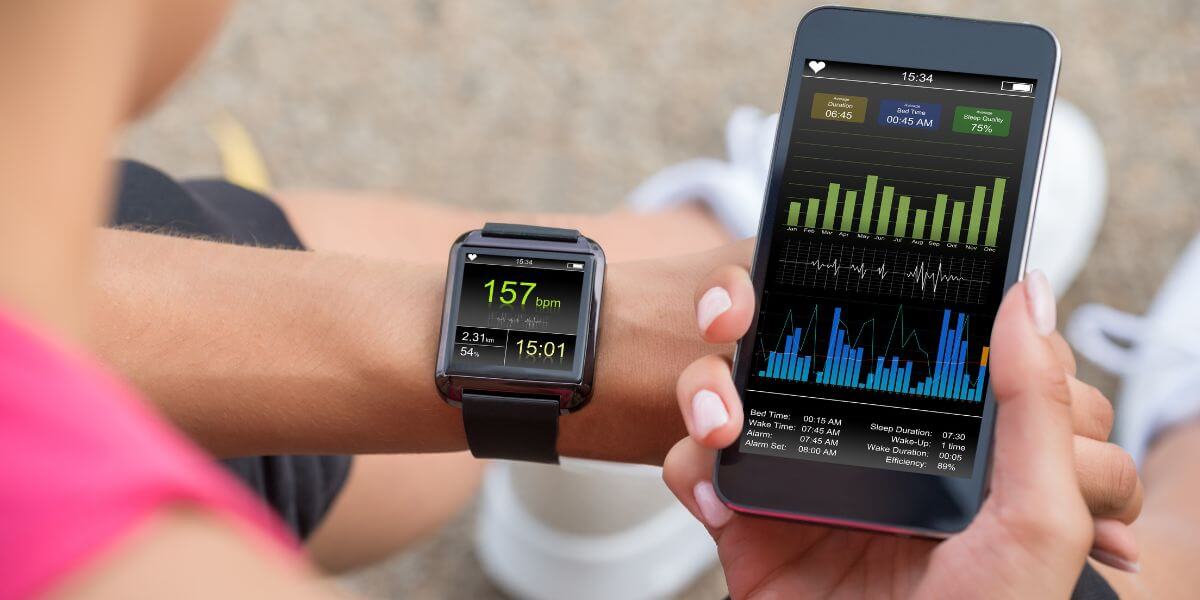 woman looking at fitness tracker and phone