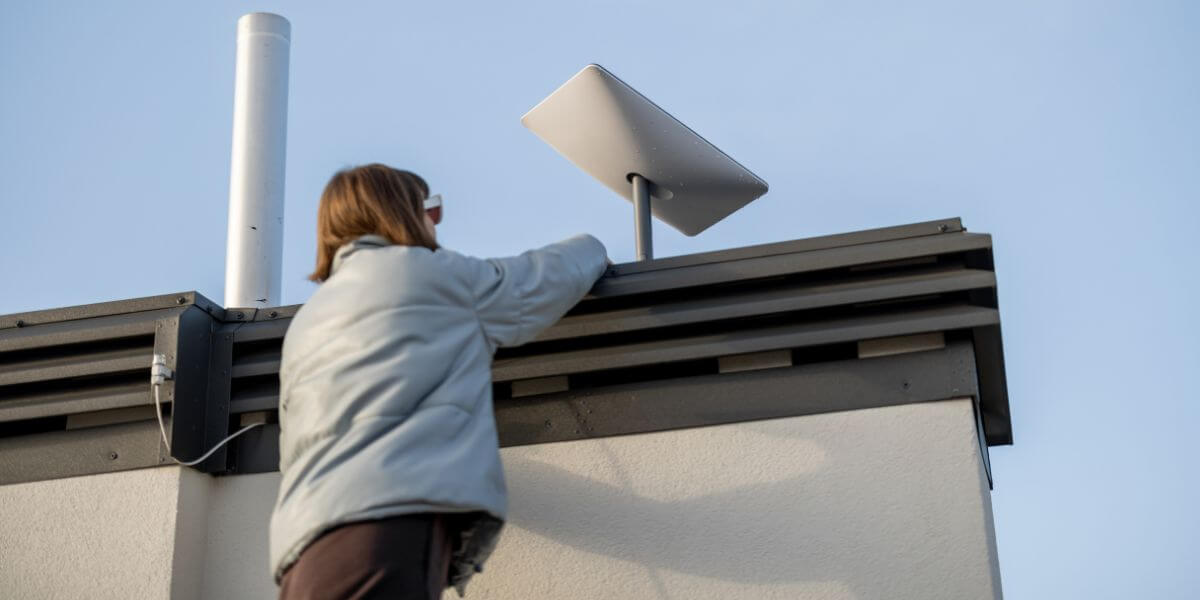 woman adjusting rooftop satellite