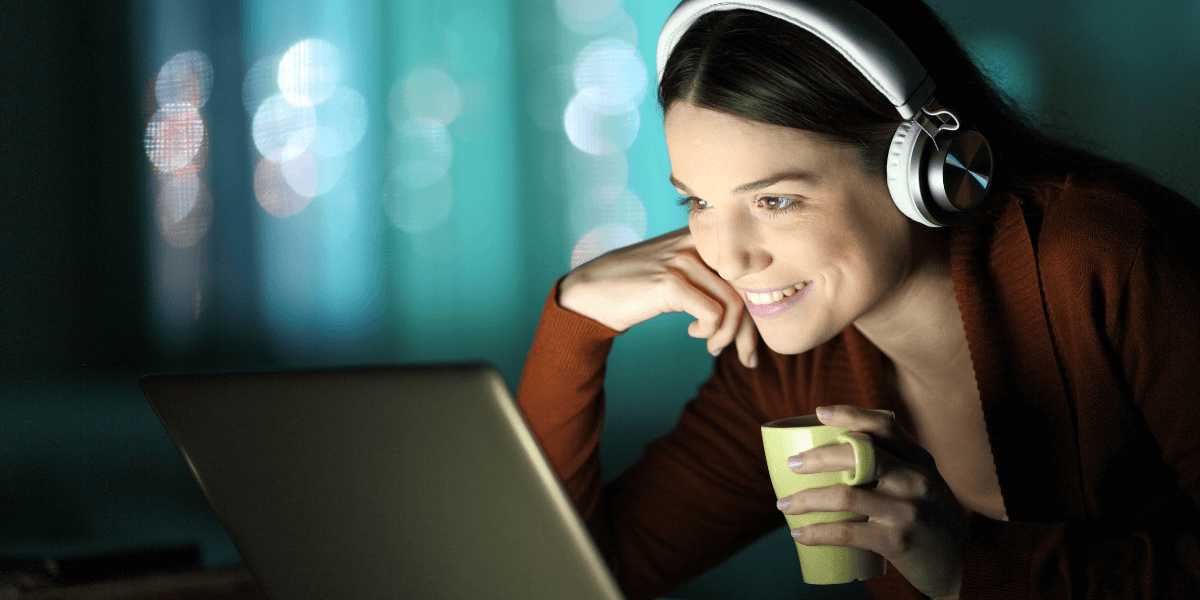 woman with headphones watching something on laptop