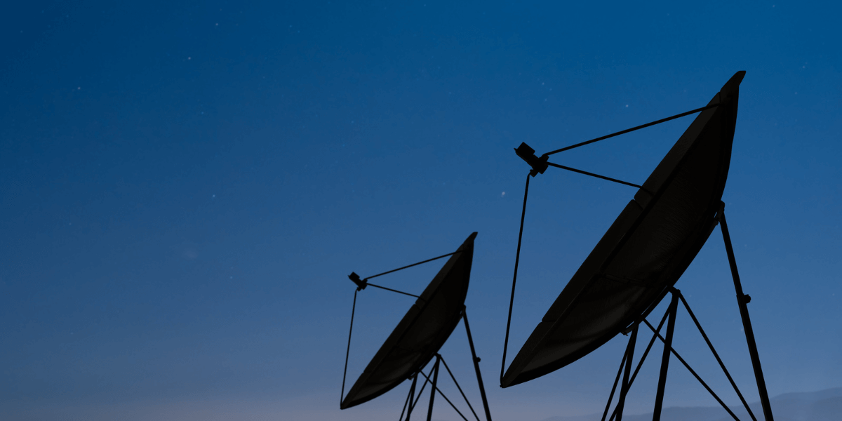 two satellite dishes with a blue backdrop