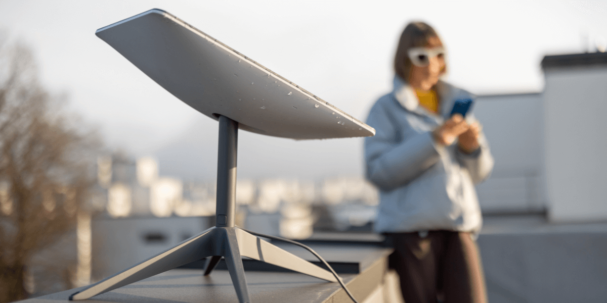 Woman using a portable satellite dish on rooftop