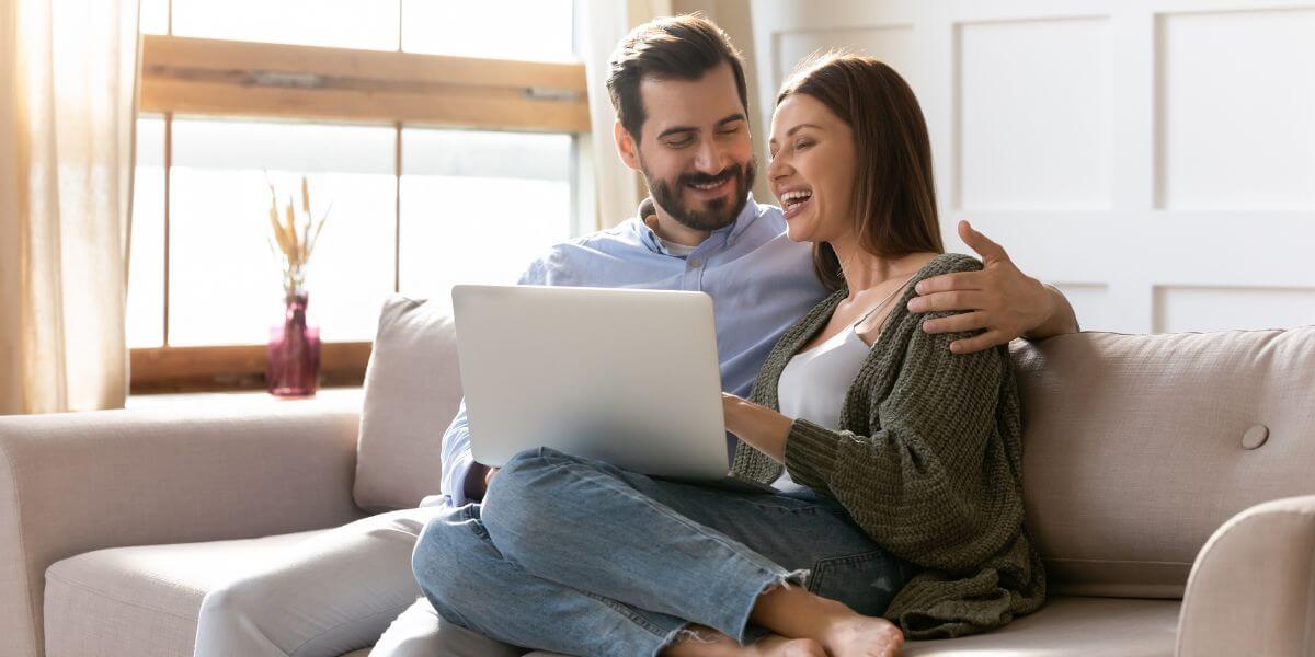 man and woman on couch with laptop
