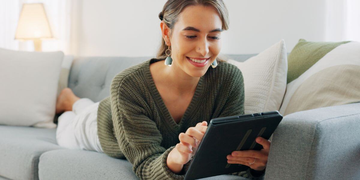 woman on couch using tablet