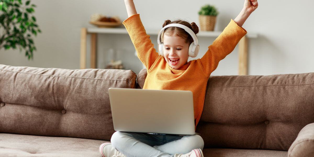 young kid using headphones with laptop