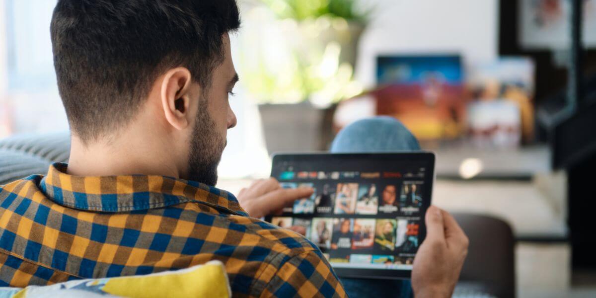 man with tablet looking at movies