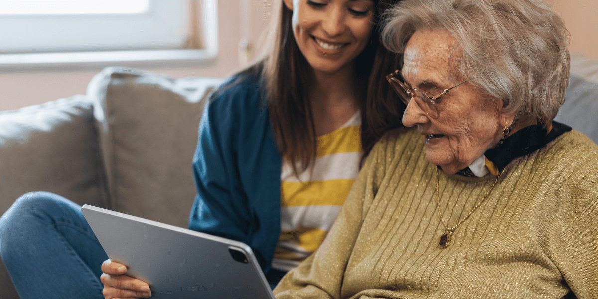 young woman and elderly woman looking at laptop
