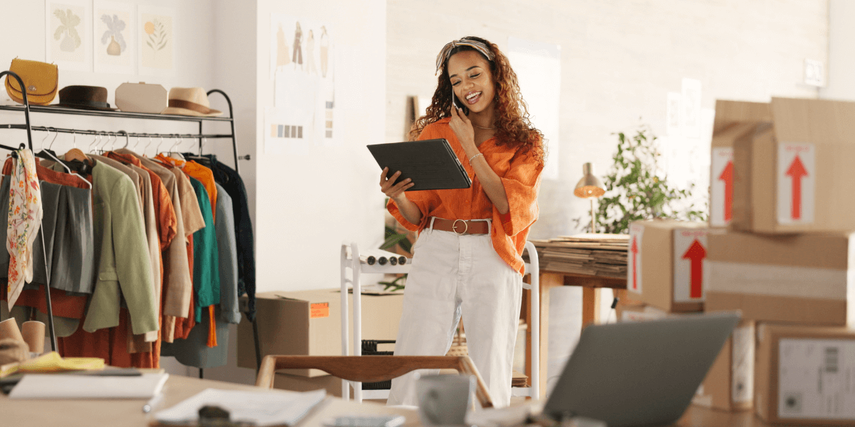 Small business owner on phone looking at tablet