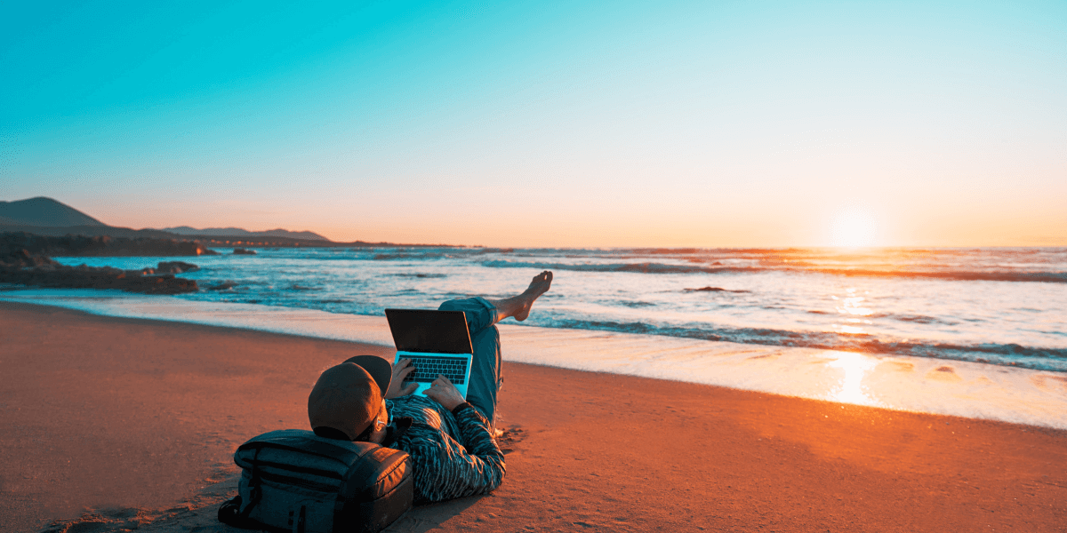 man on laptop on the beach