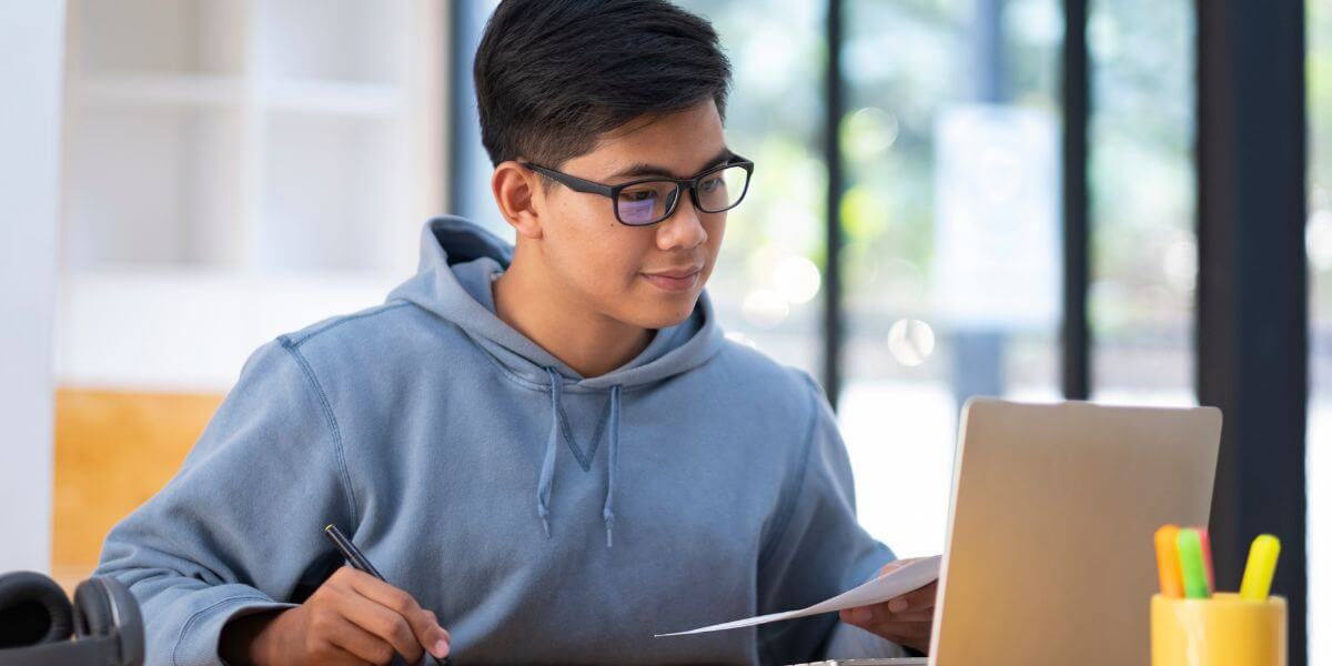 male student working on laptop in library